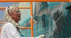 Mary Carole Larson MBPAF Mural artist while painting mural